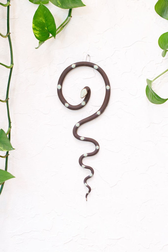 Simple contemporary ceramic snake wall decoration, with the top of the snake shaped loosely like a question mark and the tail hangs down in an organic s curve. This snake is Stevie, dark brown with light turquoise glazed head and dots.