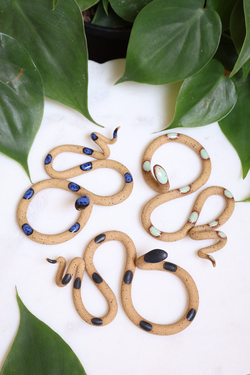 Desert curated set of three small ceramic snakes in the following colorways, Selena (speckled tan clay with blue glaze dots), Selma (speckled tan clay with light turquoise glaze dots), Sammy (speckled tan with black glaze dots).