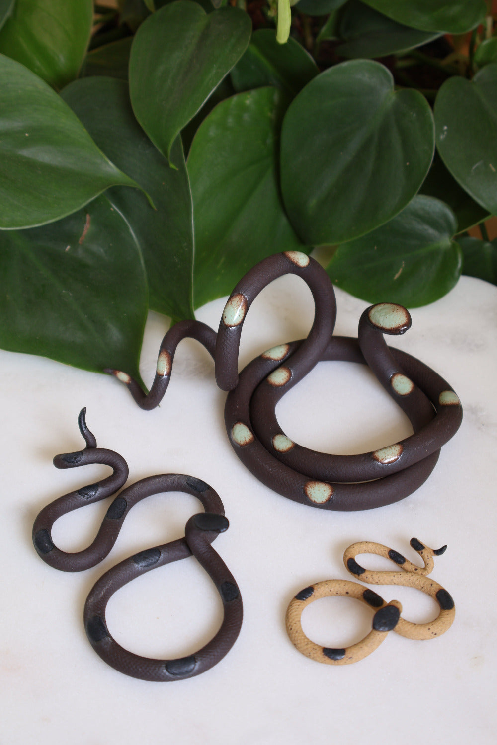 Set of three ceramic snake sculptures featuring a medium Sylvia (ivory clay with turquoise dots), a small Selma (speckled clay with turquoise dots) and a baby Sofie (ivory clay with pink dots). This is the Garden set. 